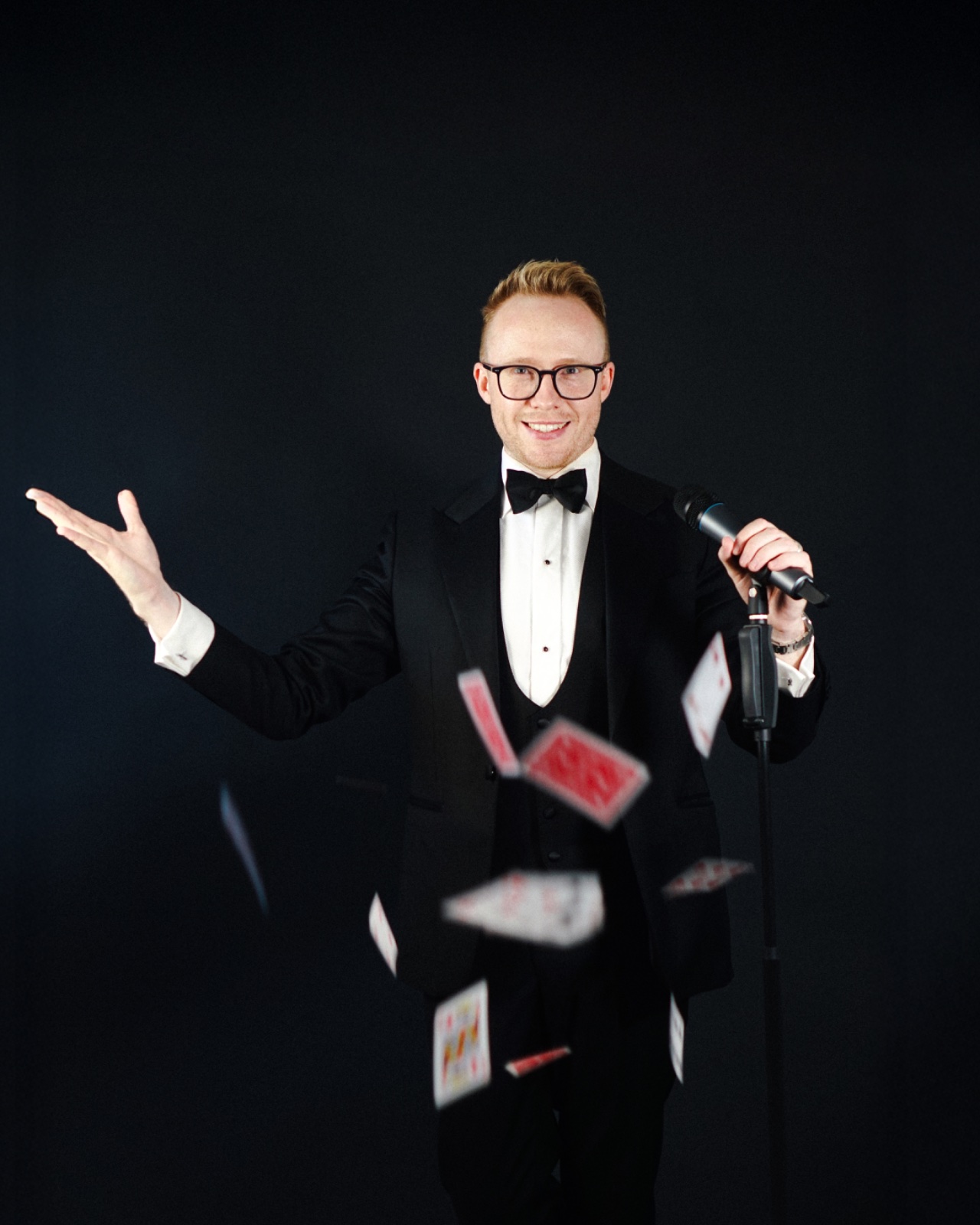 Kristian Grey in black tie with cards in motion